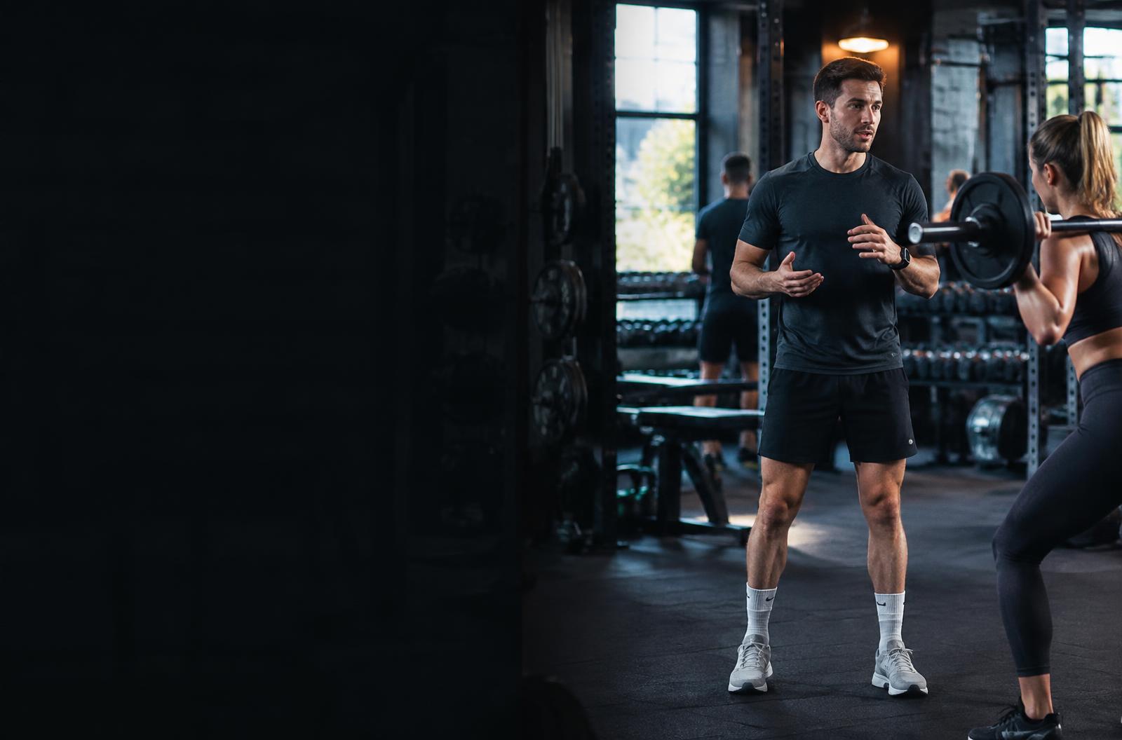 Personal trainer coaching a client in the gym